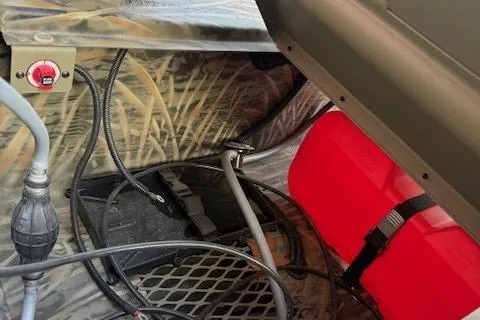 Slide: The Image of Interior view of 2025 Tracker Grizzly 1650 T Prairie Wings Edition boat, featuring wiring and red fuel tank. - 4