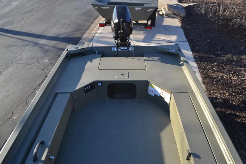 Slide: The Image of 2025 Tracker Grizzly 1654 T Sportsman boat, top view, parked on pavement. - 3