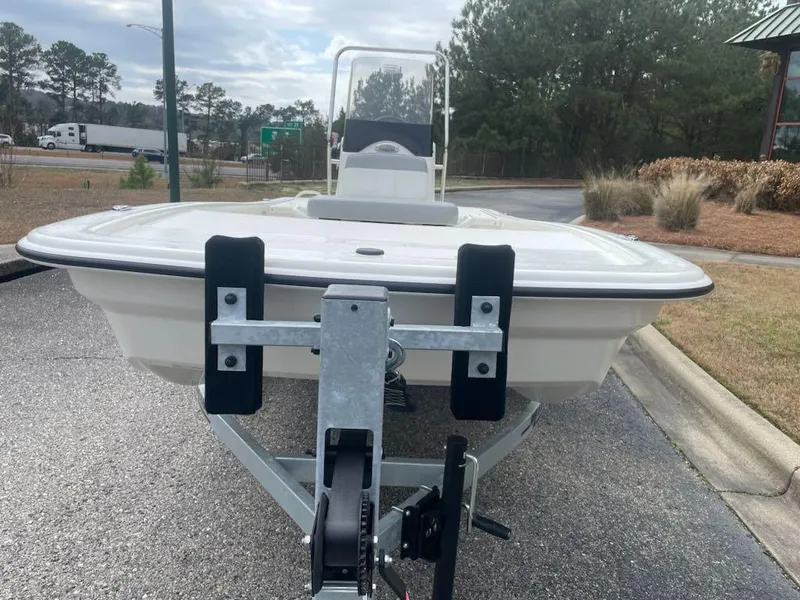 Slide: The Image of 2025 Mako Pro Skiff 13 CC on trailer, parked outdoors near trees and road. - 3