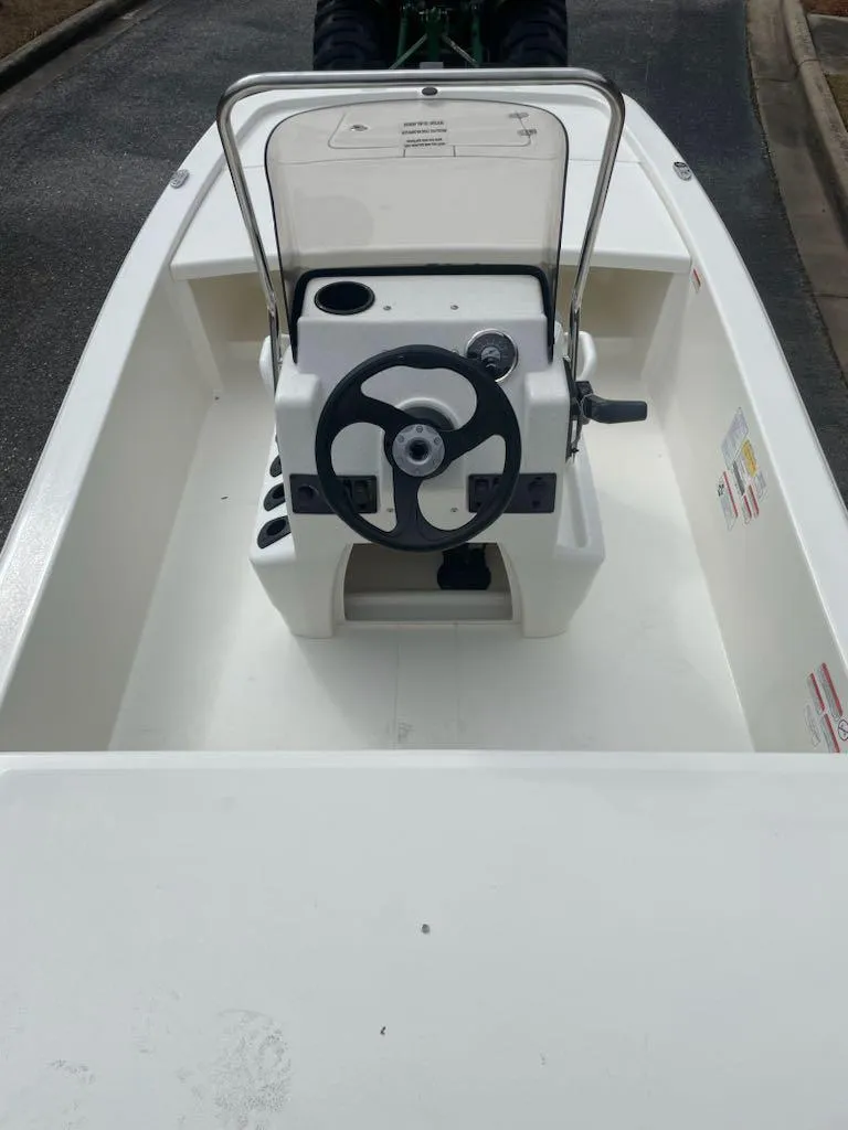 Slide: The Image of 2025 Mako Pro Skiff 13 CC boat interior with steering console and controls. - 5