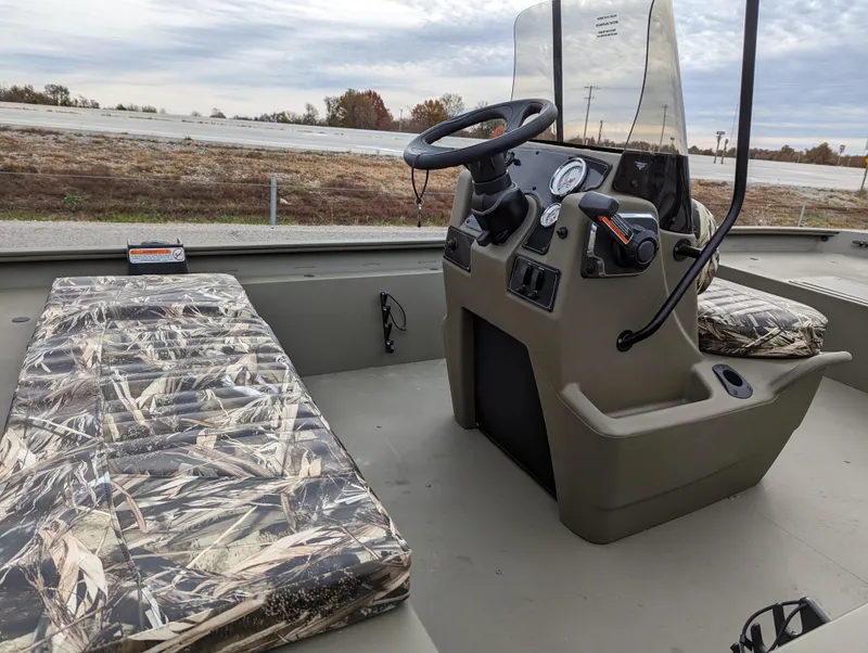 Slide: The Image of 2025 Tracker Grizzly 1860 CC boat interior with camouflage seating and steering console. - 11