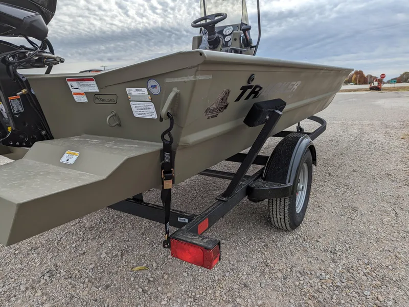 Slide: The Image of 2025 Tracker Grizzly 1860 CC boat on trailer, parked on gravel, under cloudy sky. - 5