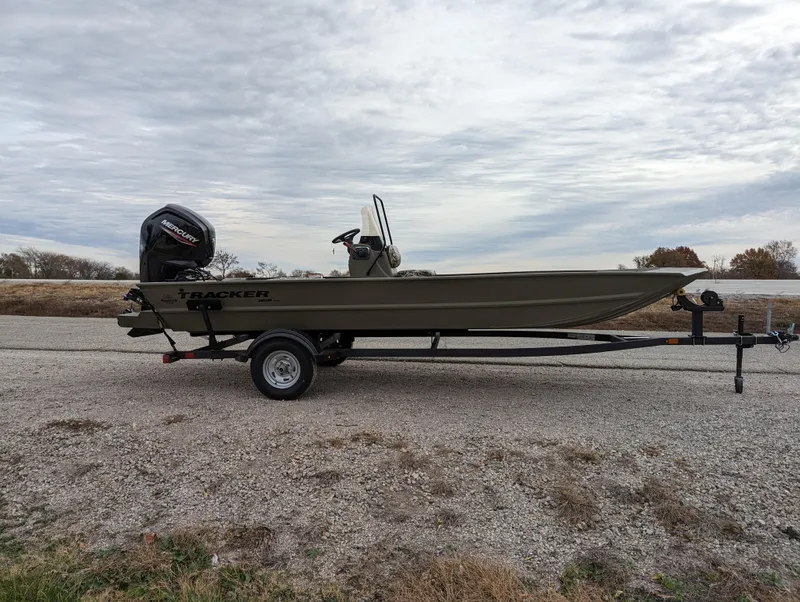 Slide: The Image of 2025 Tracker Grizzly 1860 CC boat on trailer, parked outdoors under cloudy sky. - 7
