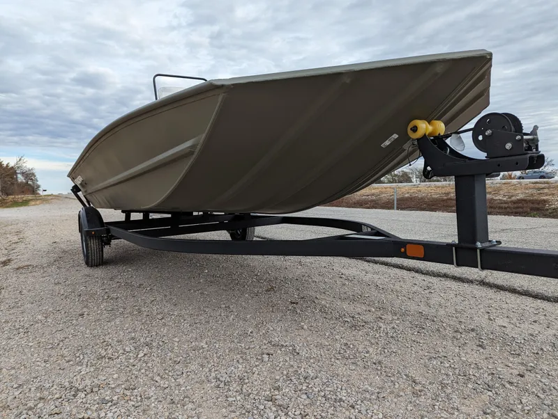 Slide: The Image of 2025 Tracker Grizzly 1860 CC boat on trailer, parked on gravel road. - 9