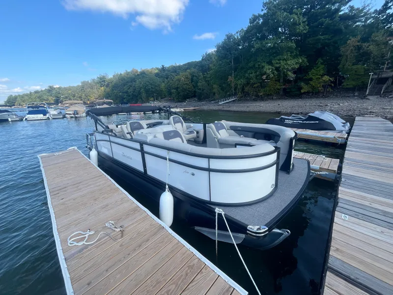 Slide: The Image of 2024 Barletta ARIA 22QC pontoon boat docked on a sunny day. - 2