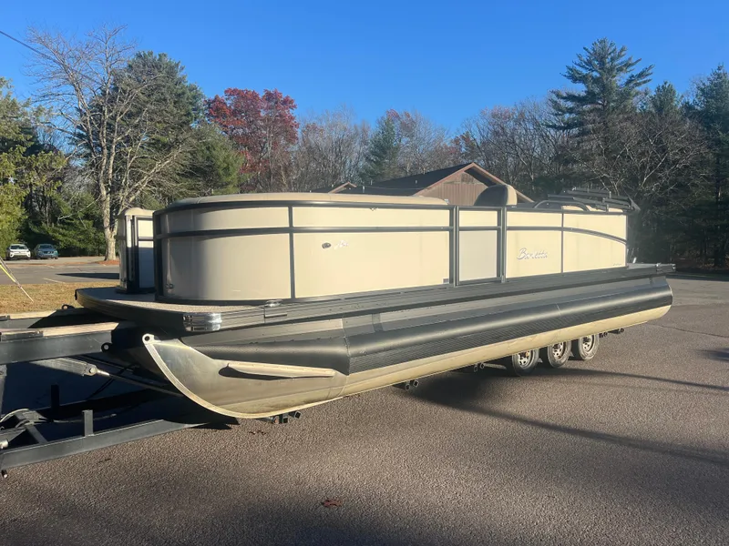 Slide: The Image of 2024 Barletta ARIA 22QC pontoon boat on trailer, parked outdoors. - 5