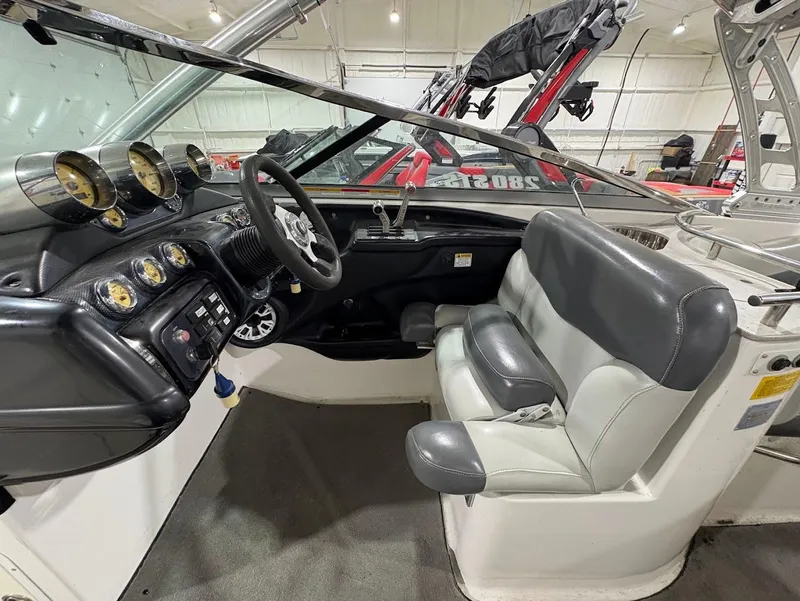 Slide: The Image of 2005 MasterCraft X-80 boat interior with steering wheel, gauges, and gray seating. - 12