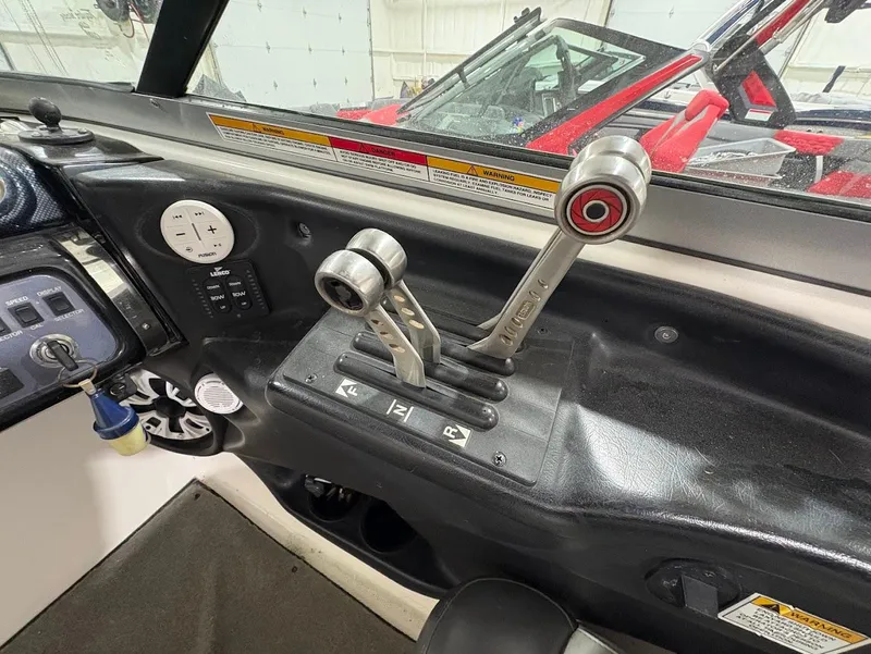 Slide: The Image of 2005 MasterCraft X-80 boat controls and dashboard, featuring dual throttle levers and gauges. - 13