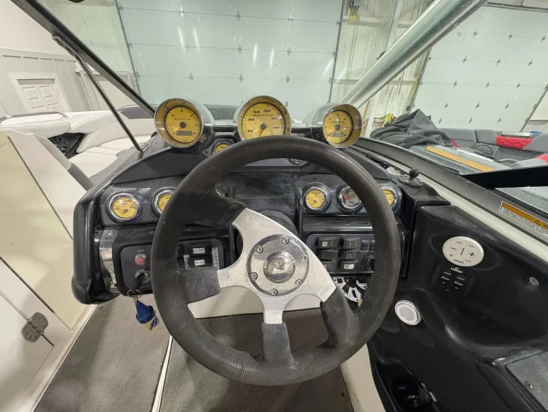 Slide: The Image of 2005 MasterCraft X-80 boat dashboard with steering wheel and gauges in a garage setting. - 14