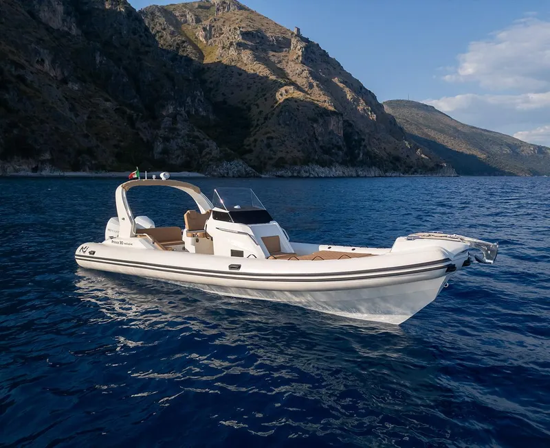 Slide: The Image of 2025 Nuova Jolly Prince 30 Exclusive boat on scenic blue water near rocky coastline. - 8