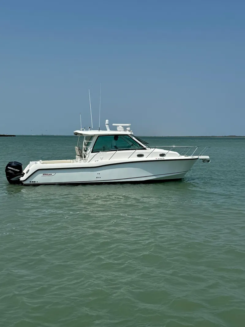 Slide: The Image of 2014 Boston Whaler 345 Conquest boat on calm water under clear blue sky. - 0