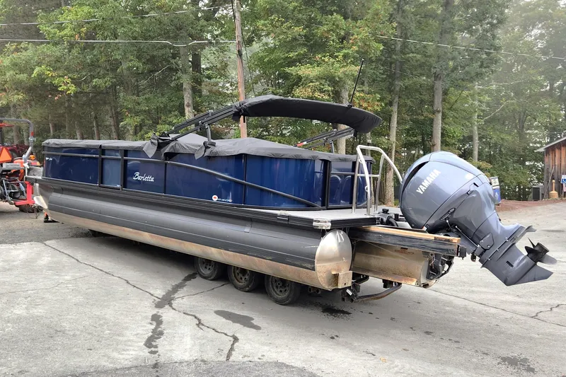 Slide: The Image of 2024 Barletta Aria 24QC pontoon boat with Yamaha outboard motor on a trailer. - 2