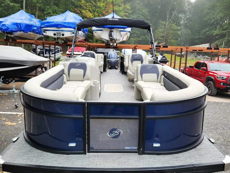 Slide: The Image of 2024 Barletta Aria 24QC pontoon boat with spacious seating, parked outdoors. - 4