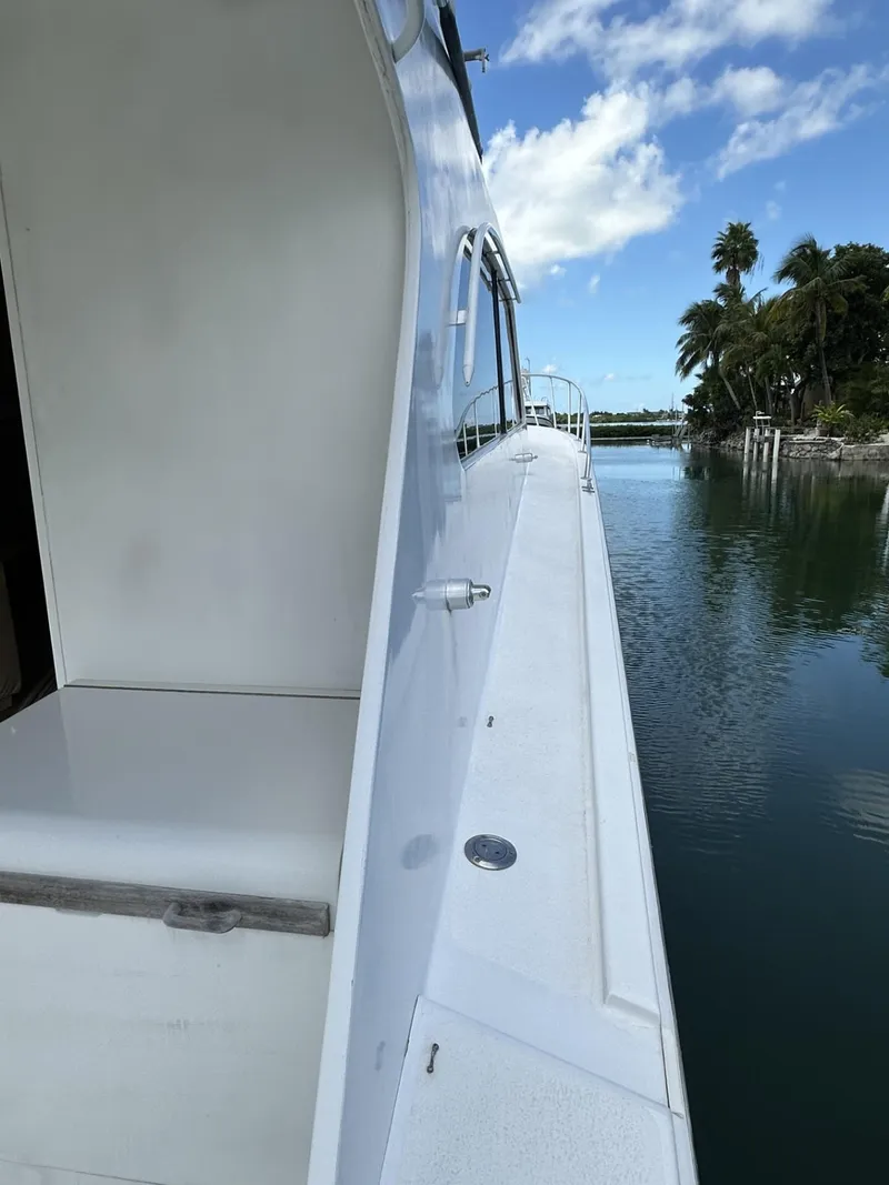 Slide: The Image of 1998 Post 50 Sportfish yacht docked by tropical waterway with palm trees. - 12