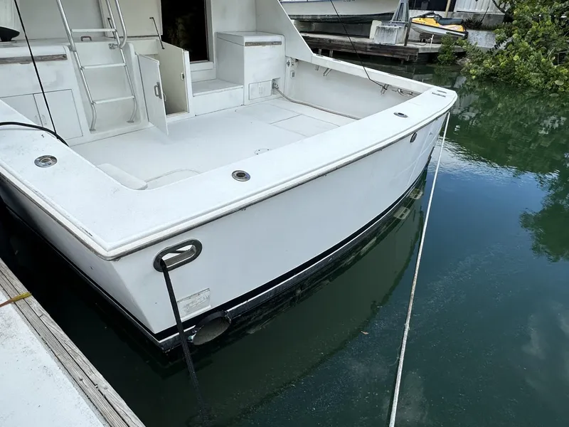 Slide: The Image of 1998 Post 50 Sportfish boat docked, showing spacious deck and clean white exterior. - 13