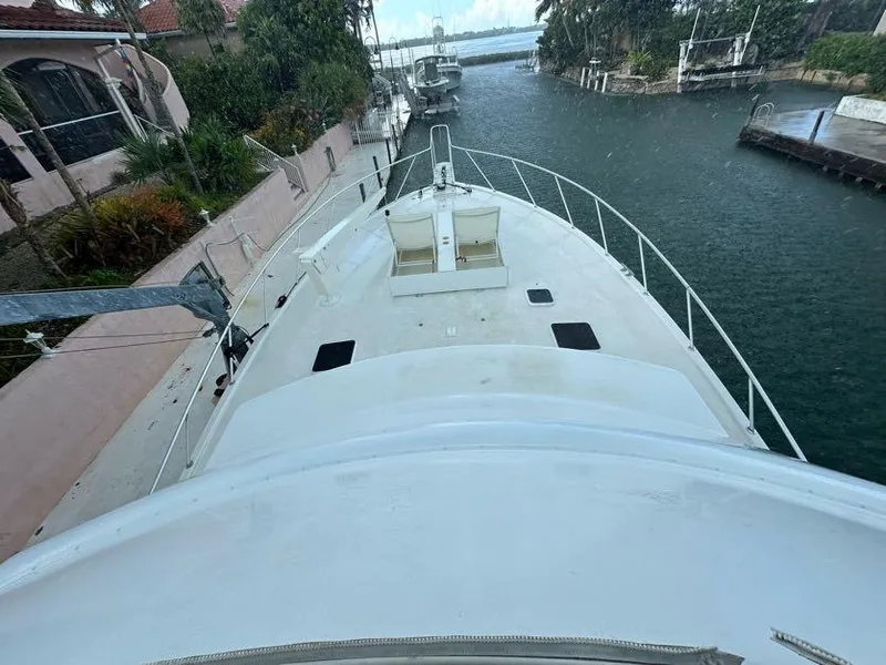 Slide: The Image of 1998 Post 50 Sportfish boat docked in a canal, surrounded by lush greenery. - 26