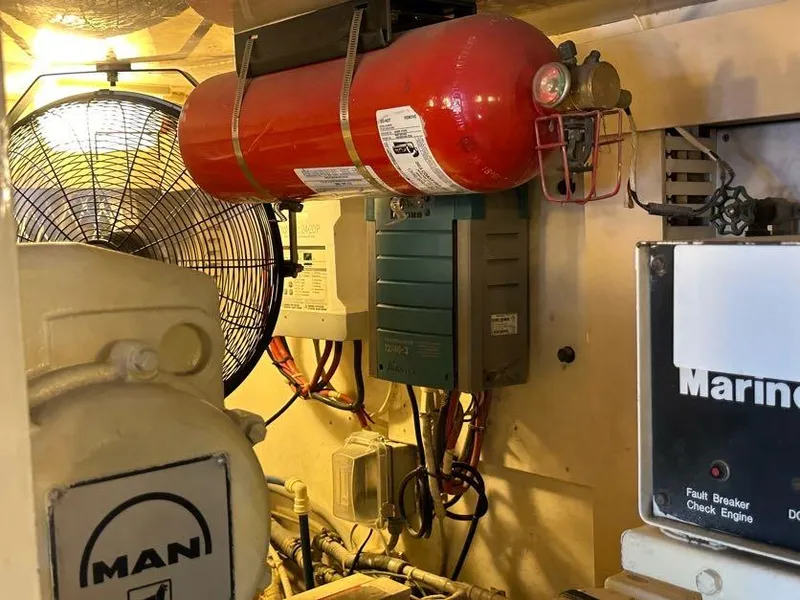 Slide: The Image of Engine room of 1998 Post 50 Sportfish with fire extinguisher and electrical components. - 28