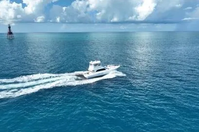 Slide: The Image of 1998 Post 50 Sportfish cruising on open ocean under blue sky and clouds. - 3