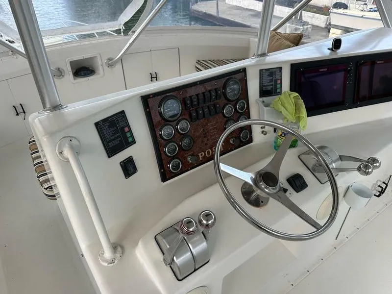Slide: The Image of 1998 Post 50 Sportfish helm with gauges, steering wheel, and navigation screens. - 31
