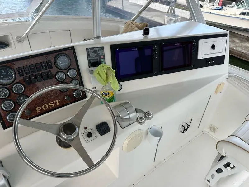 Slide: The Image of 1998 Post 50 Sportfish boat helm with steering wheel and navigation instruments. - 32