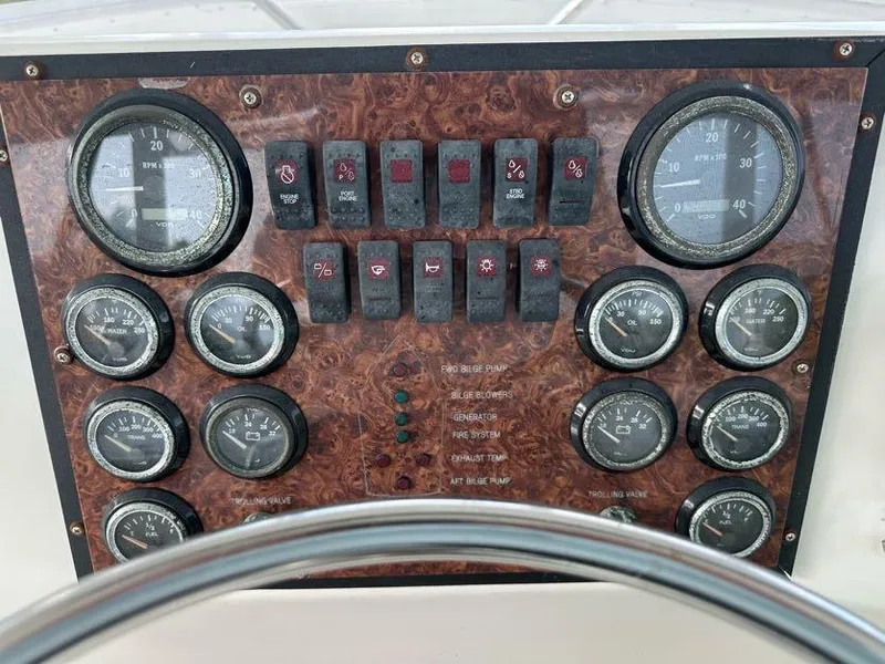 Slide: The Image of 1998 Post 50 Sportfish dashboard with gauges and switches, featuring a woodgrain panel. - 33