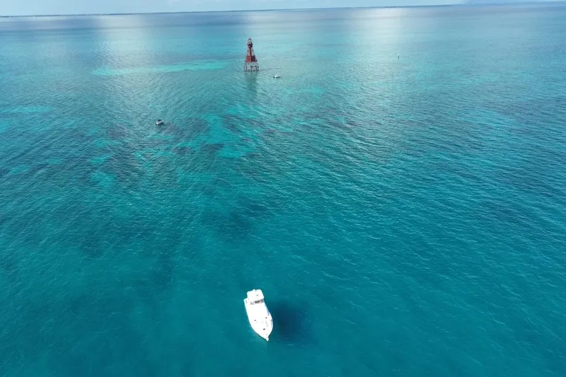 Slide: The Image of Aerial view of 1998 Post 50 Sportfish boat on clear blue ocean near a lighthouse. - 37