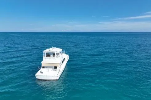 Slide: The Image of 1998 Post 50 Sportfish yacht on open ocean under clear blue sky. - 4