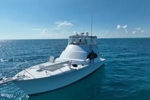 Slide: The Image of 1998 Post 50 Sportfish boat on open sea under clear blue sky. - 40