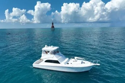 Slide: The Image of 1998 Post 50 Sportfish yacht on open sea under blue sky and clouds. - 42