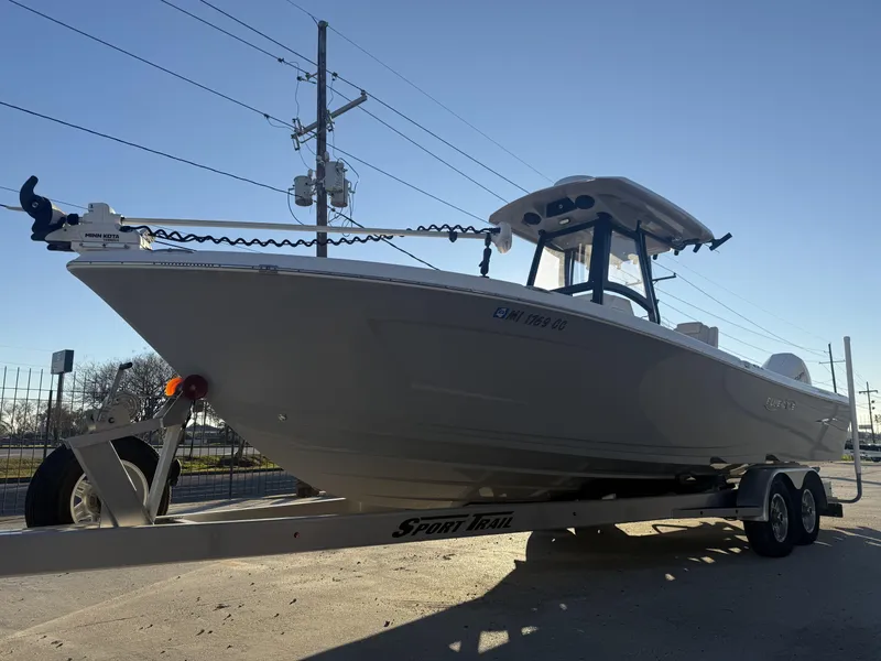 Slide: The Image of 2022 Blue Wave 2800 Makaira boat on trailer, parked outdoors under clear sky. - 18
