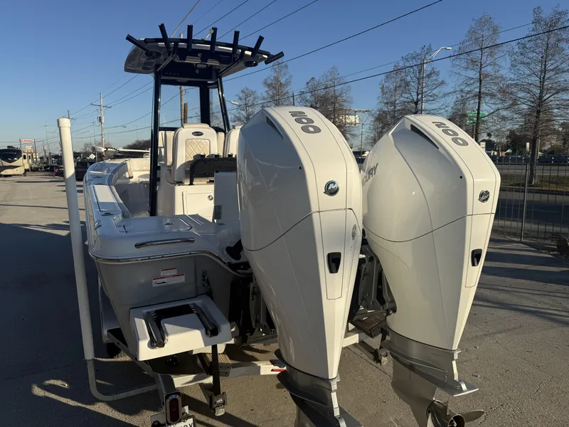 Slide: The Image of 2022 Blue Wave 2800 Makaira boat with dual outboard engines, parked on a sunny day. - 19