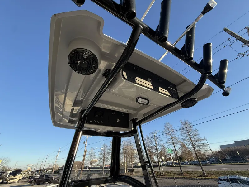 Slide: The Image of 2022 Blue Wave 2800 Makaira boat console with rod holders and speakers under clear sky. - 21