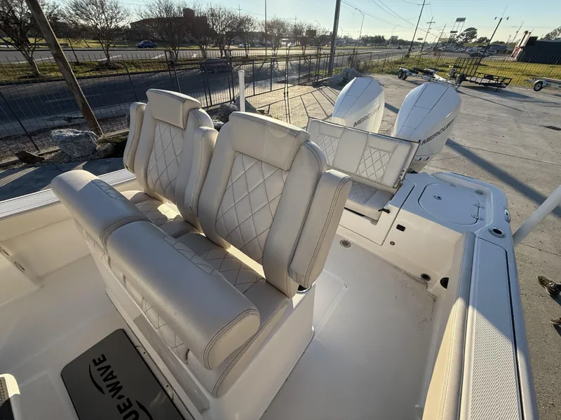 Slide: The Image of 2022 Blue Wave 2800 Makaira boat interior with cushioned seating and dual Mercury engines. - 24