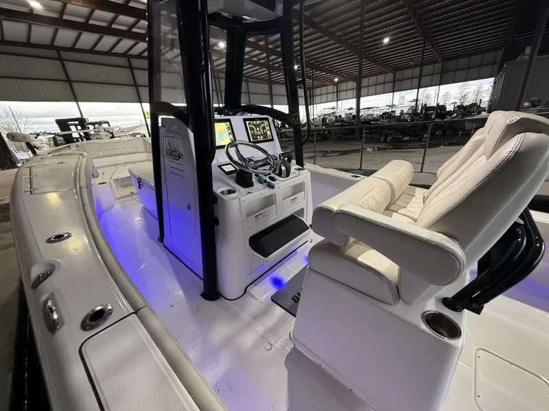 Slide: The Image of 2022 Blue Wave 2800 Makaira boat interior with illuminated console and seating. - 28
