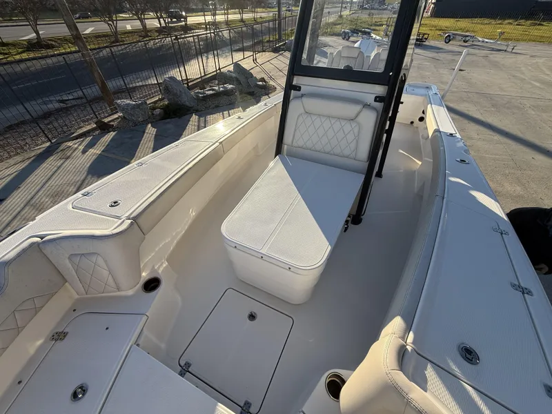 Slide: The Image of 2022 Blue Wave 2800 Makaira boat interior with cushioned seating and storage compartments. - 5