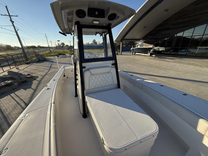 Slide: The Image of 2022 Blue Wave 2800 Makaira boat interior with seating and console, docked outdoors. - 7