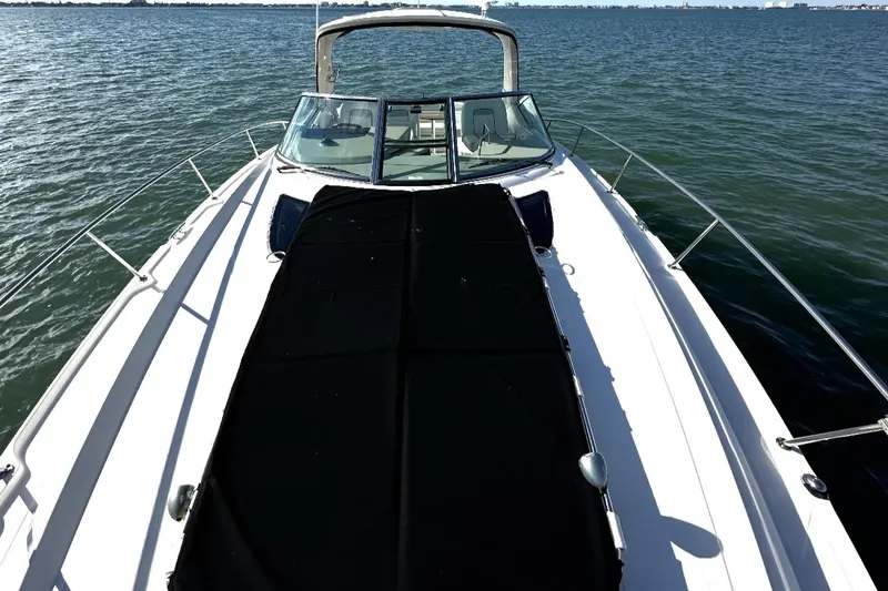 Slide: The Image of 2010 Sea Ray 370 Sundancer boat on calm water, showcasing sleek design and spacious deck. - 24