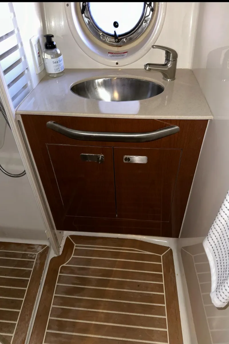 Slide: The Image of 2010 Sea Ray 370 Sundancer bathroom with wooden cabinetry and stainless steel sink. - 32