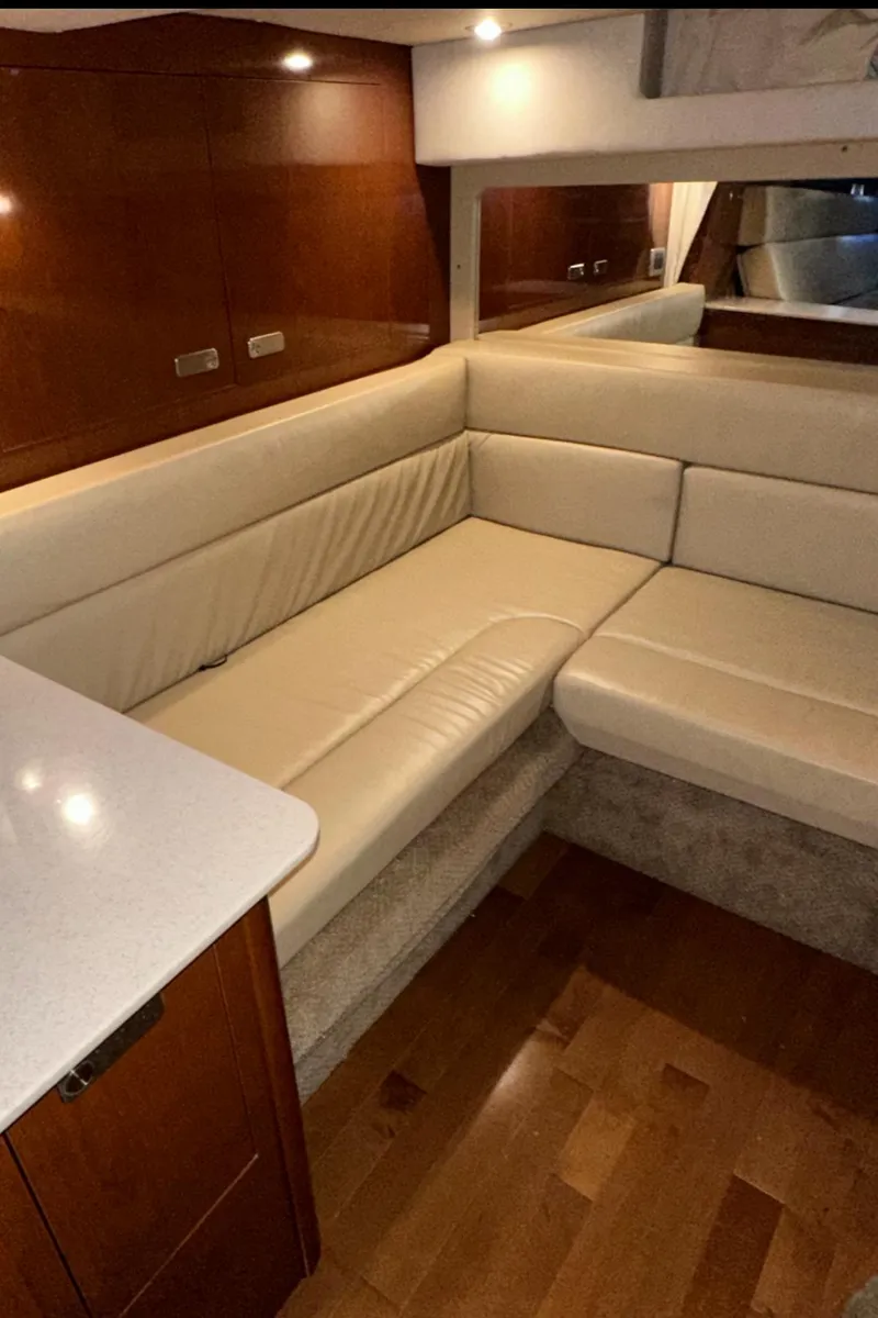Slide: The Image of Interior of 2010 Sea Ray 370 Sundancer with beige leather seating and wooden accents. - 36