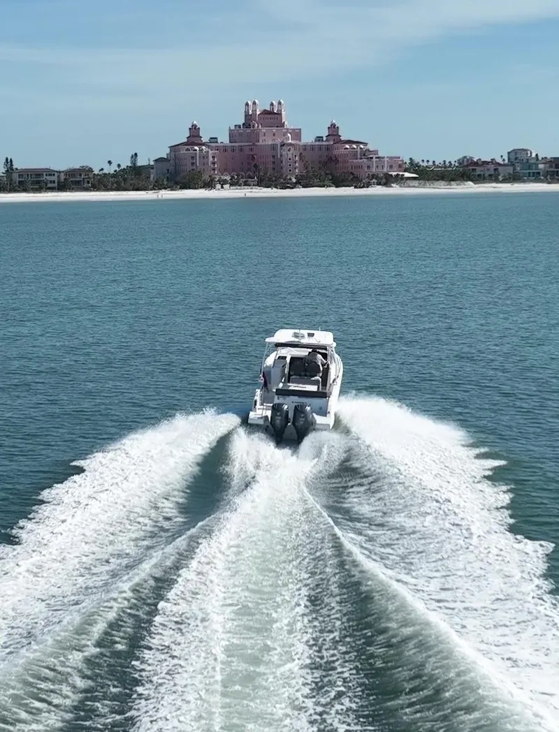 Slide: The Image of 2021 Jeanneau Leader 9.0 WA cruising on open water with a coastal backdrop. - 15