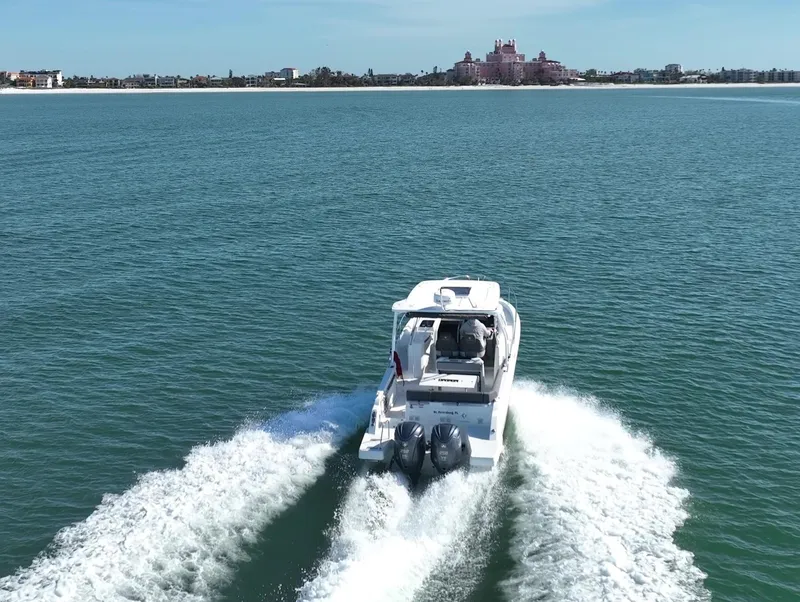 Slide: The Image of 2021 Jeanneau Leader 9.0 WA cruising on open water, distant shoreline visible. - 18
