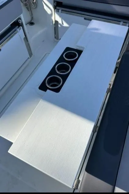 Slide: The Image of 2021 Jeanneau Leader 9.0 WA boat interior with table and cup holders. - 24