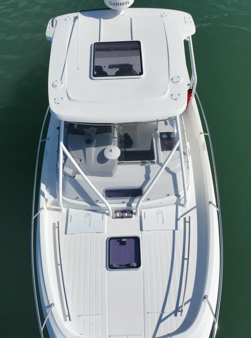 Slide: The Image of 2021 Jeanneau Leader 9.0 WA boat, aerial view, white exterior, on calm water. - 9