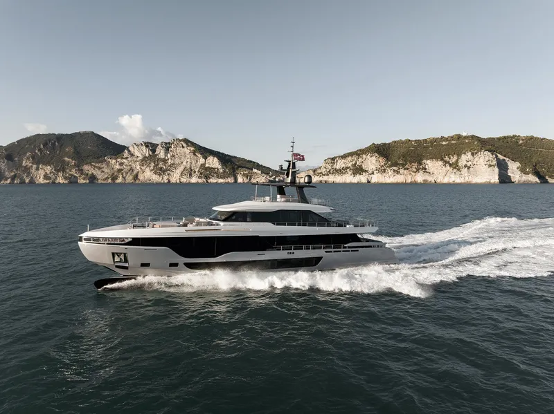 Slide: The Image of 2024 Azimut Grande 36M yacht cruising on the ocean with scenic cliffs in the background. - 35