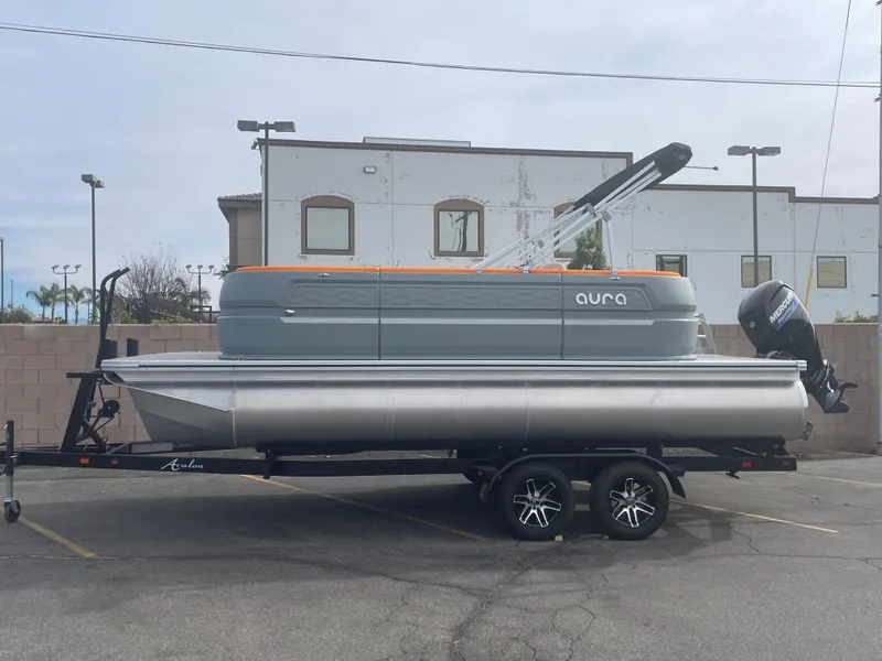 The Image of 2025 Avalon 21 AURA pontoon boat on trailer in parking lot. - 0