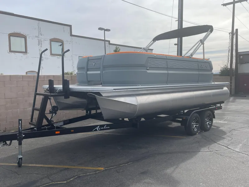 Slide: The Image of 2025 Avalon 21 AURA pontoon boat on trailer in parking lot. - 1