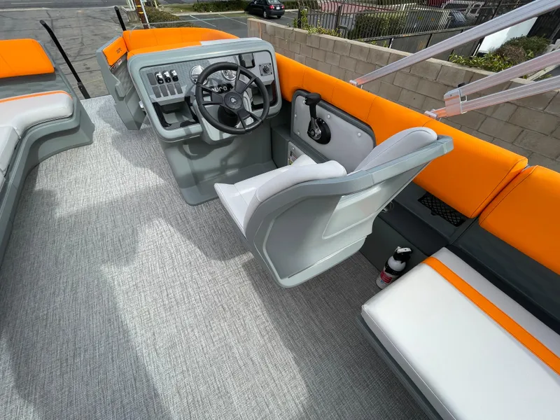 Slide: The Image of 2025 Avalon 21 AURA boat interior with orange and gray seating, steering console, and modern design. - 7