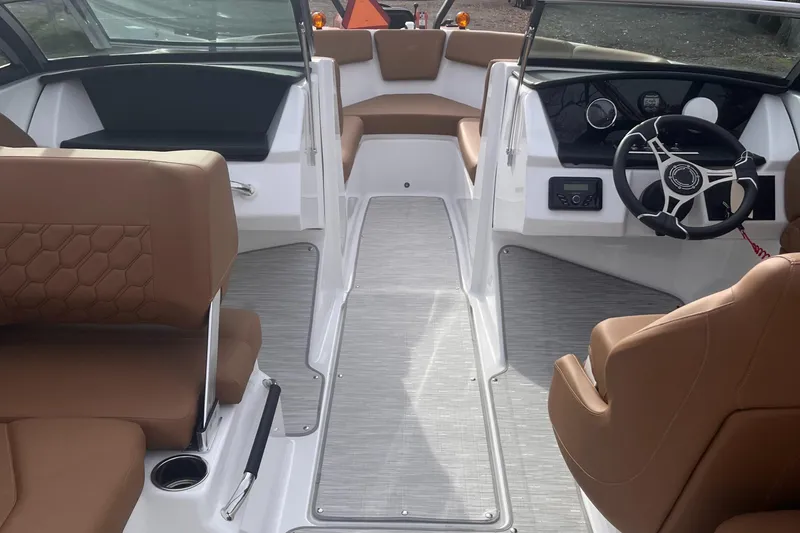 Slide: The Image of 2024 Four Winns H1 OB boat interior with brown seating and modern dashboard. - 15