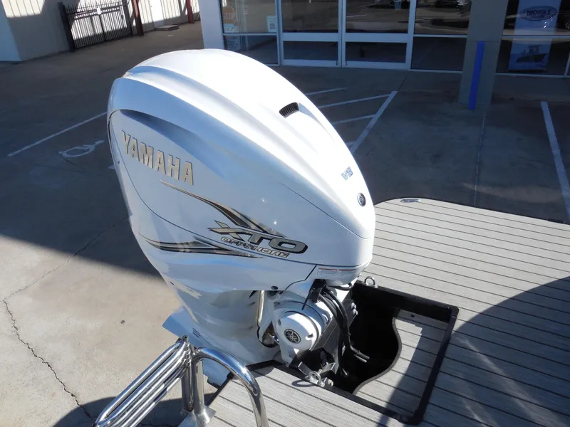 Slide: The Image of Outboard motor on a 2019 SunCatcher Amara boat, parked in a lot. - 12