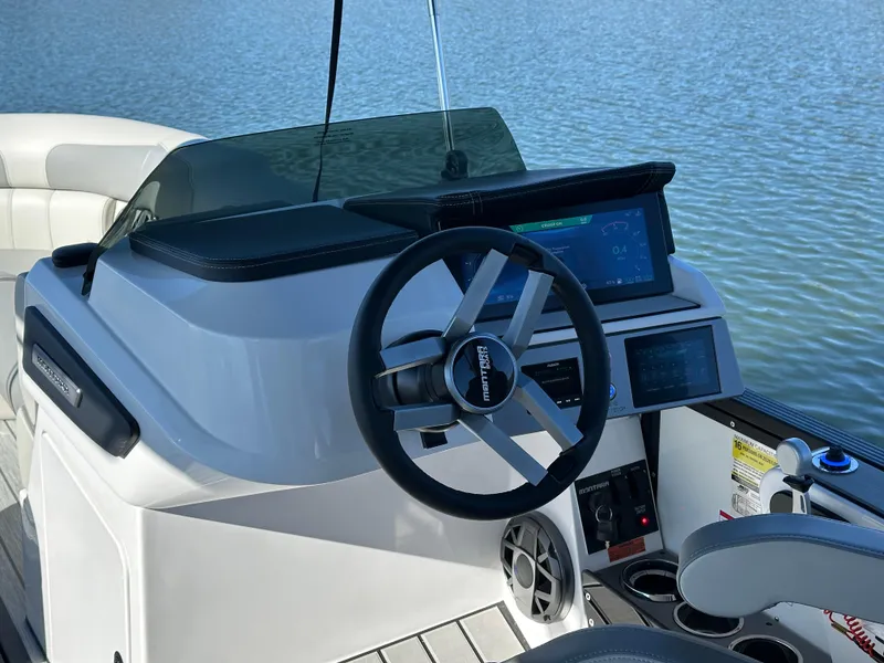 Slide: The Image of 2025 Montara Surf Boss 2.0 25 boat dashboard with steering wheel and digital displays. - 10